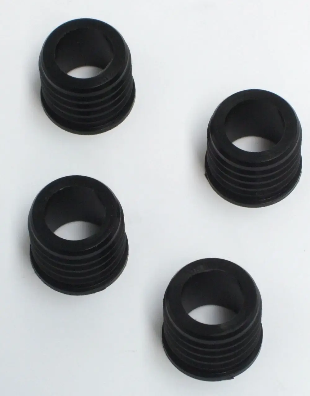 Vier schwarze Lippendichtringe in zylindrischer Form, geeignet für Anwendung mit Daikin Solaris. Sie weisen eine gerillte Oberfläche auf und haben ein hohles Innendesign.